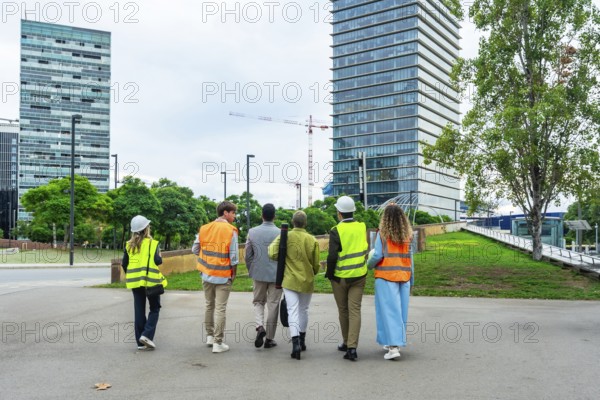 Diverse team of construction professionals and architects wearing safety vests and hard hats