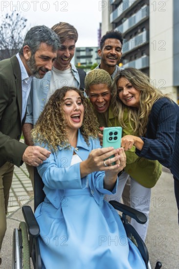 Diverse group of happy colleagues and friends, including a woman in a wheelchair, sharing a joyful