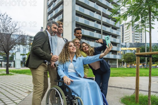 Diverse group of business colleagues, including a woman in a wheelchair, smiling and taking a