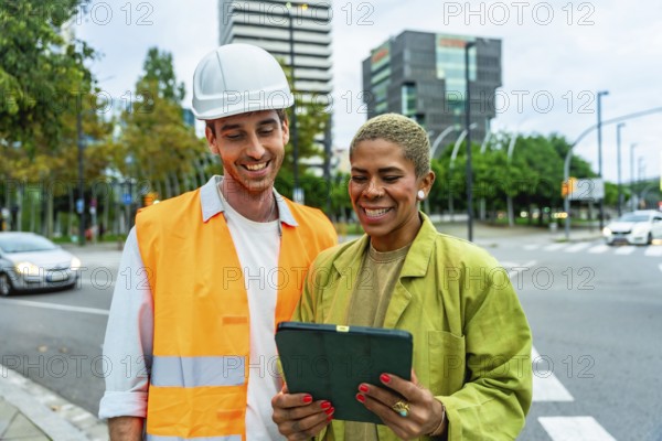 Construction manager man in hard hat and woman architect reviewing building plans on a digital