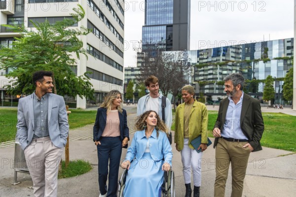 Diverse group of smiling business people, including a woman in a wheelchair, actively collaborating