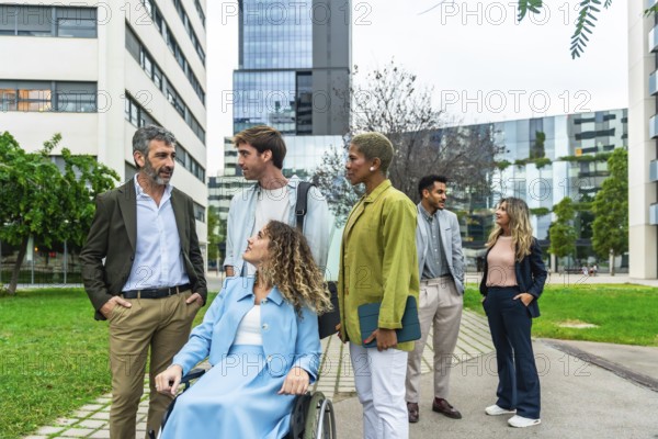 Group of diverse business professionals, including a woman using a wheelchair, collaborating and