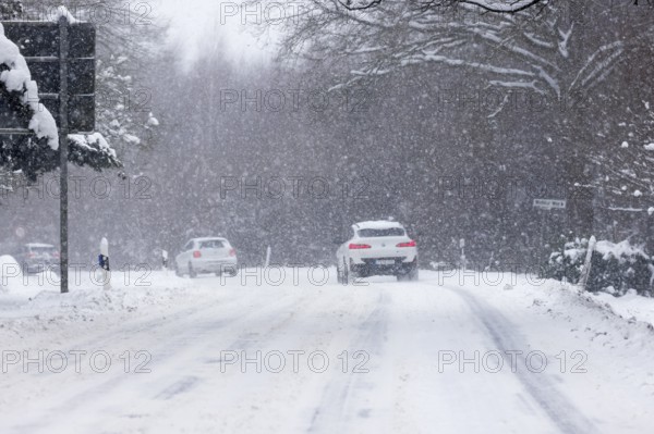 Road traffic in winter, cars driving on heavily icy roads covered with snow and black ice in