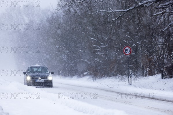 Road traffic in winter, car driving on heavily icy road covered with snow and black ice in a