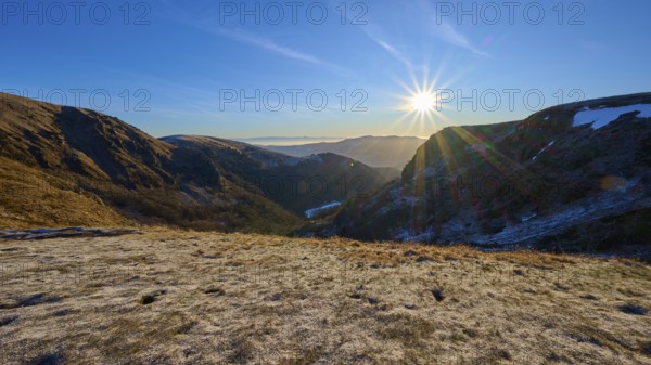 Frost-covered mountain landscape at sunrise with clear sky and bright sunlight, winter, Route de