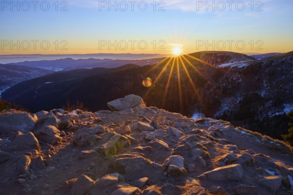 Rocks on a mountain peak at dawn under a setting sun, looking towards the Rhine Valley, viewpoint,