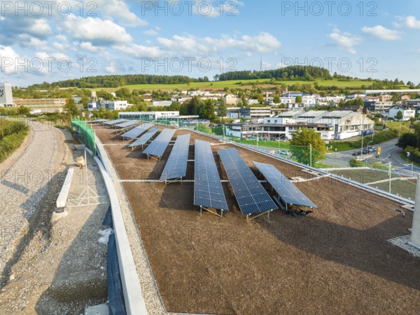 Solar systems on a flat roof with wide green areas and buildings in the background, new Park and