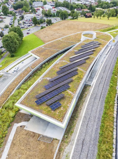 Roof with solar systems near roads and train lines, nestled in nature, new park and ride parking
