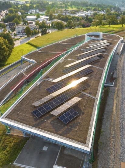 A roof area with solar panels, illuminated by the evening sun, in a rural area, new park and ride