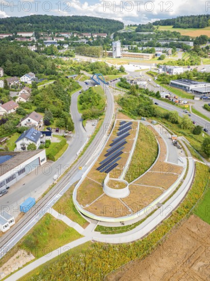 High view of a hilly landscape with solar panels and surrounding residential buildings, new Park