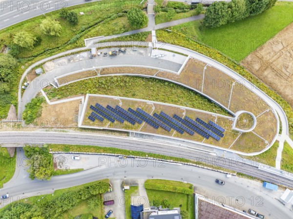 Large solar systems on a covered parking lot surrounded by roads and greenery, new Park and Ride