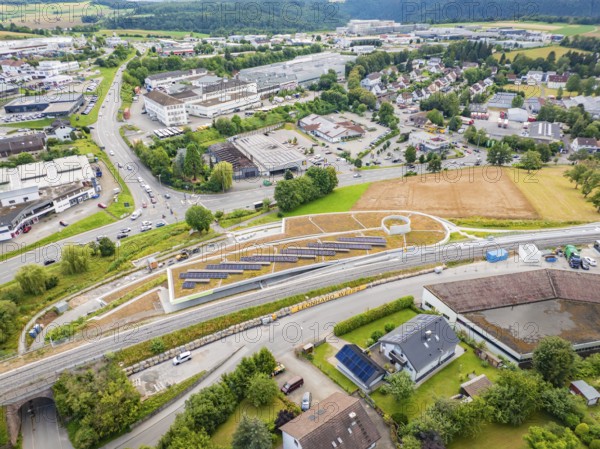 City panorama with solar systems on a hill in the middle of industrial buildings, new park and ride