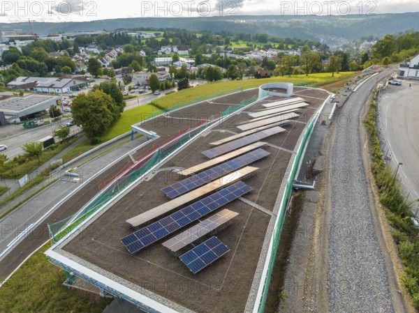 Expanded solar system on a roof with a view of a green landscape and city, new park and ride