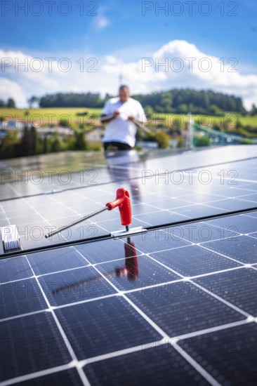Close-up of a solar module with a working person in a rural area, new Park and Ride parking garage