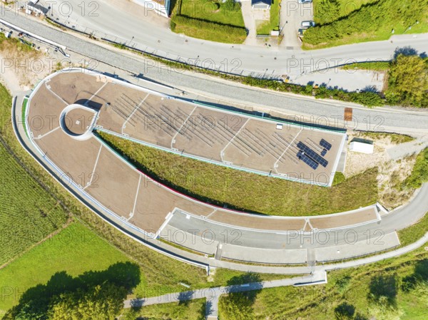 Bird's eye view of an architectural structure with solar panel and surrounding roads, new park and
