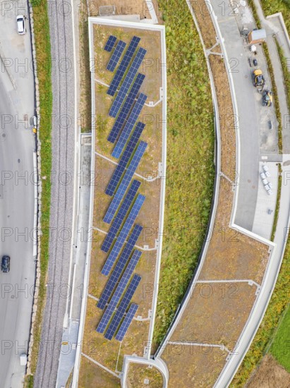 Aerial view of solar roof area in an urban area with plants and paths, new park and ride parking