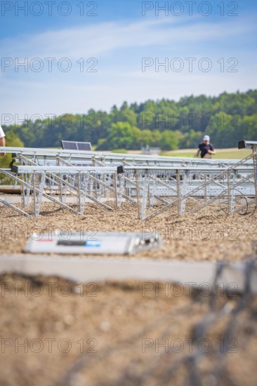 Workers prepare to install solar panels in an open field, new park and ride Calw Heumaden car park