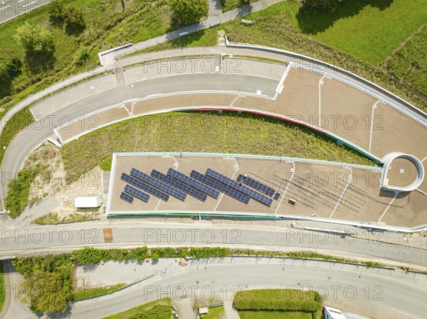 Aerial view of solar panel system on roof next to road and green area, new park and ride parking