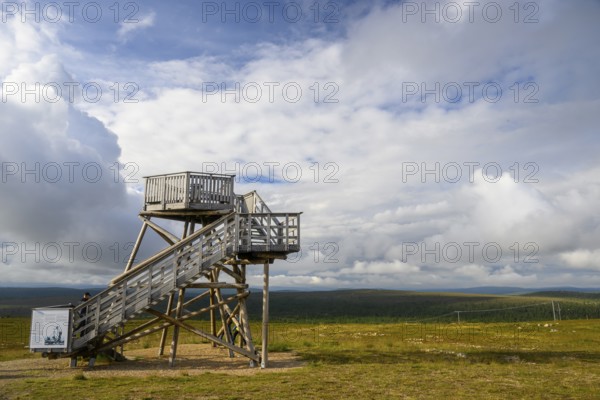 Wooden observation tower in a vast landscape under a partly cloudy sky, Kaunispää Caabuaivas,