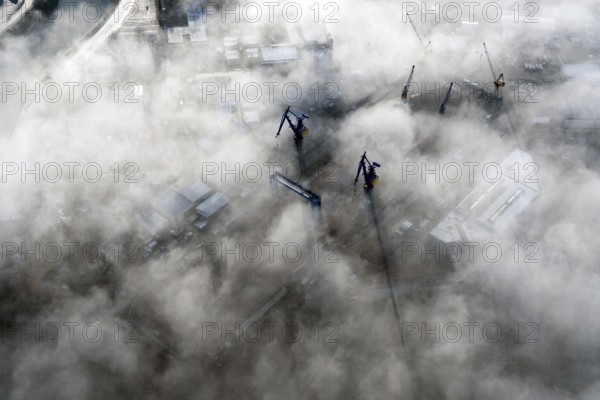 Blohm and Voss, Lürssen shipyard, cranes looking out of the fog, Hamburg, Elbe, Germany,