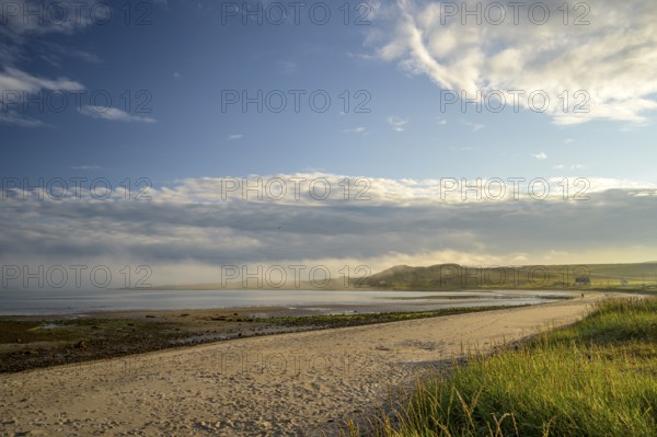 Idyllic morning atmosphere on a coast with beach, grass and wide sky on the beach of Kiberg, Troms,