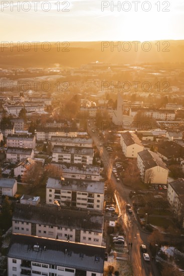Residential areas in a city under a warm sunset sky, with glowing streets, Calw, Black Forest,