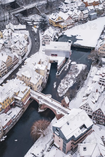 A snowy town with a river surrounded by bridges and picturesque houses, Calw, Black Forest, Germany