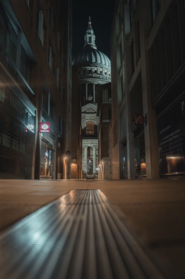 Illuminated St Paul Cathedral through a modern narrow path with a symmetrical angle, London,