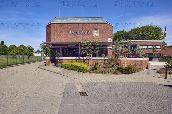 Town hall, brick building, flat roof, modern architecture, flower bed, hedge, street made of