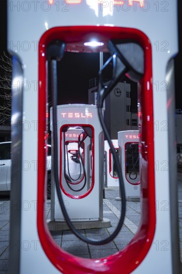 Tesla charging stations at night with red lighting and modern optics, Tesla Supercharger,