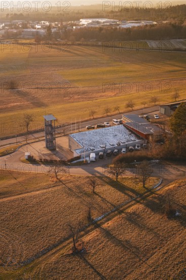 Fire station in a rural winter landscape with long shadows and snow-covered fields, Althengstett,