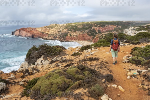 Hiking woman, view over cliff, Fishermens Trail, Rosa Vicentina, western Algarve just north of cape