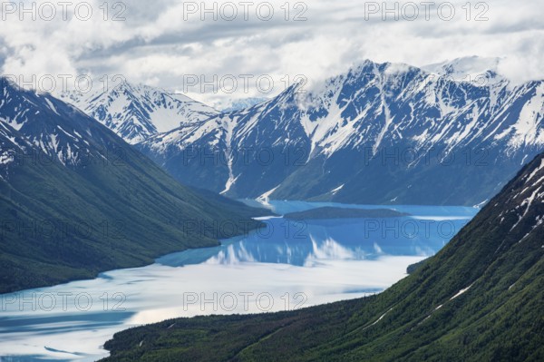 View of snowy mountains in spring and turquoise Kenai Lake with reflection, Slaughter Ridge Trail,