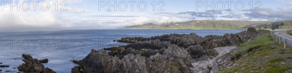 Atmospheric coastal landscape with cloudy sky over a vast sea on the coastal road in the north of