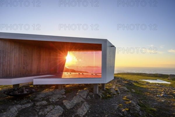 Modern building with glass wall in front of sunset on Mount Domen, sea view, nestled in rocky