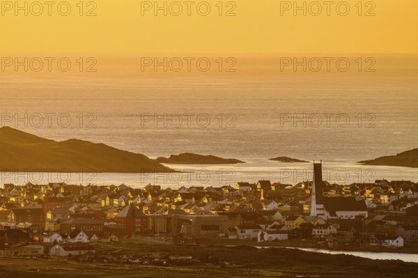View of the city of Vardø from Mount Domen, sea at sunset with golden sky and calm atmosphere,