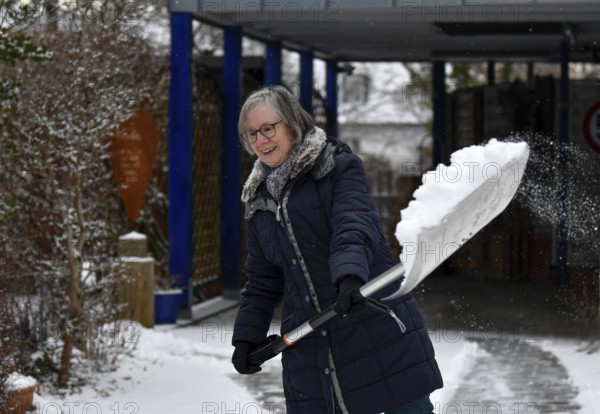 Elderly woman sweeping week with snow shovel, snow shovel, snow remover, shovel, clear, shovel