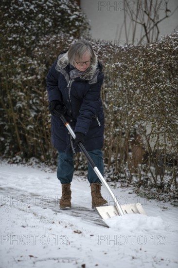 Elderly woman sweeping week with snow shovel, snow shovel, snow remover, shovel, clear, shovel