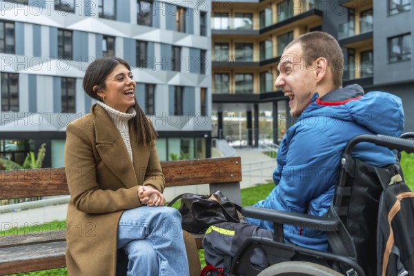 Young woman and man with a physical disability in a wheelchair sharing a joyful moment and smiling