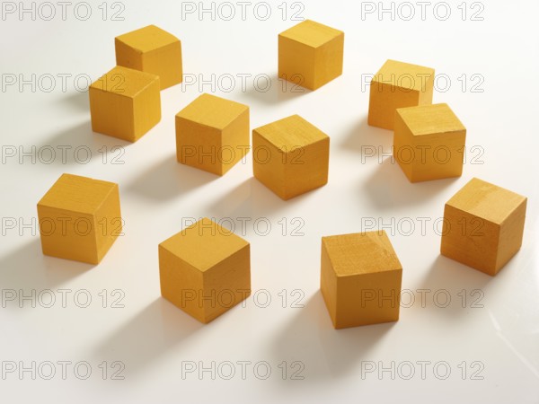 11 yellow wooden cubes against a white background