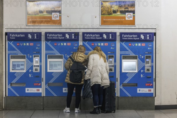 Ticket vending machine at Stuttgart Airport with travelers buying a public transport ticket.
