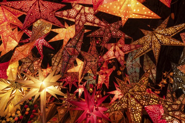 December 22, 2025, many glowing Christmas stars hanging at a market stall near St. Paul's Church,