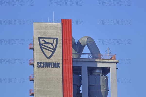 Silo with inscription and emblem of Zementfabrik Schwenk Manufacture of cement, tower with pipes,