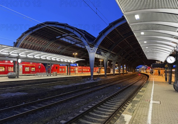 Empty platform with the two-nave platform hall and regional express in the evening, central railway