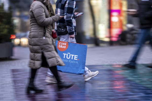 Pedestrian zone, passers-by hurrying, shopping between the years, exchanging, shopping bags,