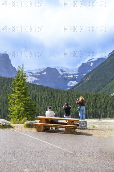 Tourists capturing breathtaking glacier views from a roadside stop along the scenic icefields