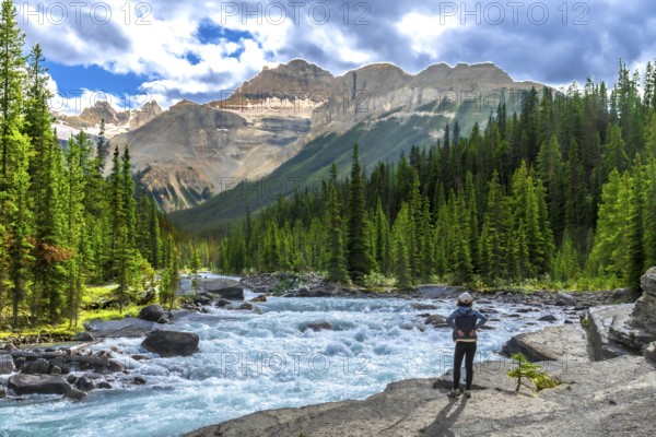 Hiker enjoying breathtaking views of turquoise waters flowing through mistaya canyon in banff