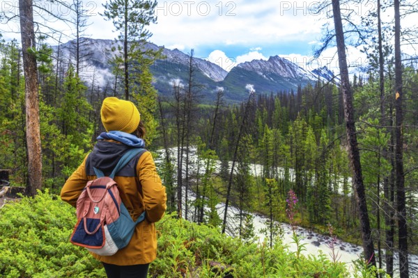 Female hiker with backpack enjoying the breathtaking view of sunwapta falls and the majestic