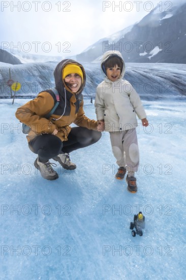 Mother and her child are enjoying a memorable adventure on the athabasca glacier, surrounded by the