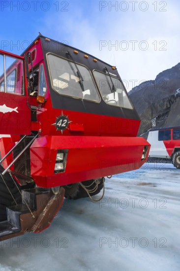 Red ice explorer bus parked on the athabasca glacier, offering breathtaking views of the canadian